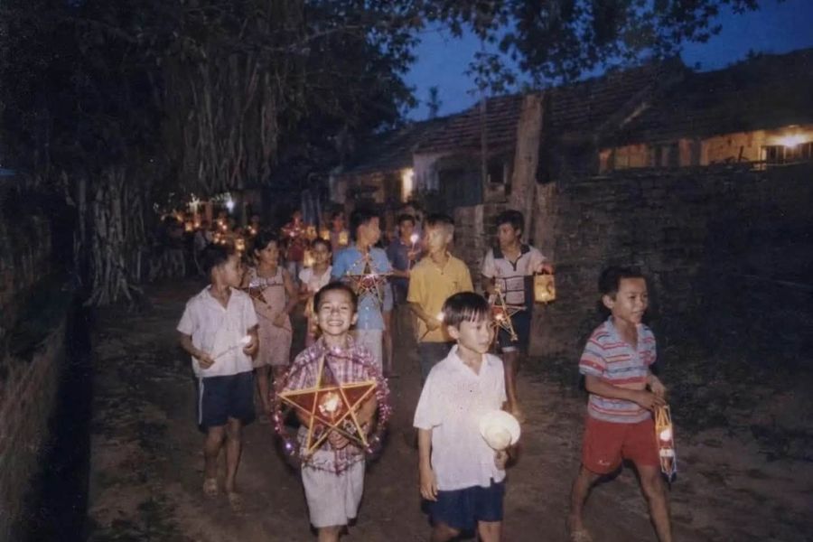 Des enfants participant à une danse du lion dans un village pendant la fête de la Mi-Automne.