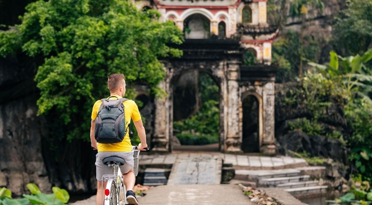 Des voyageurs à vélo découvrant les paysages verdoyants autour de la pagode Bích Động à Ninh Bình.
